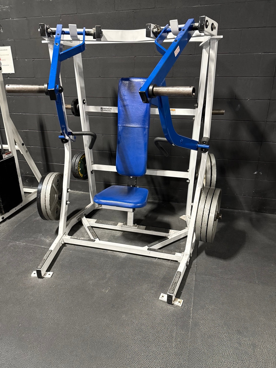 Blue plate-loaded shoulder press machine at Full Tilt Barbell Club